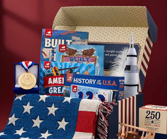 USA 250 Tour prize bundle: patriotic books, a commemorative medallion, model rocket and airplane, and a star-pattern throw blanket